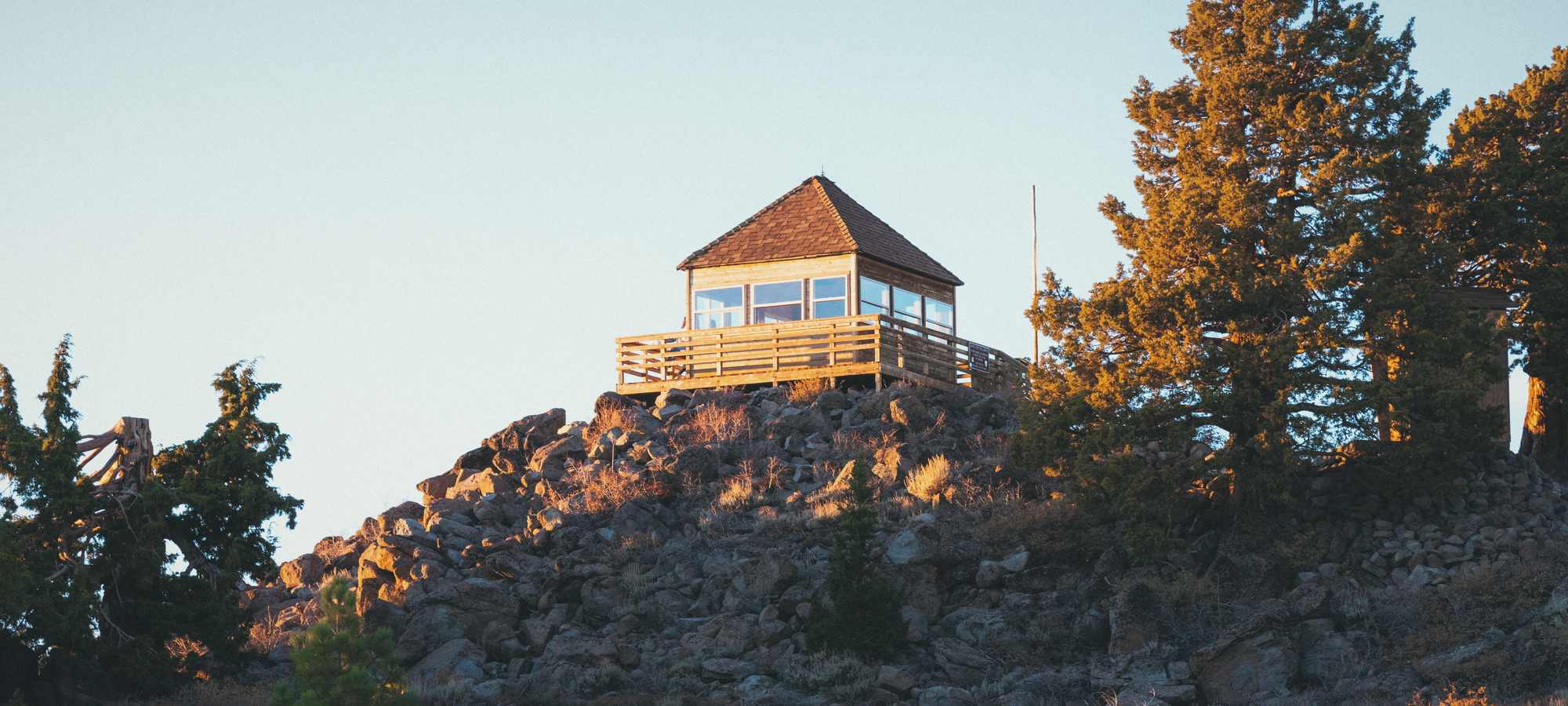 The Martis Peak fire lookout on its rocky summit in late sun.