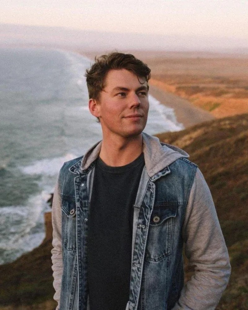 Thomas, the owner, photographed on a coastline at sunset.