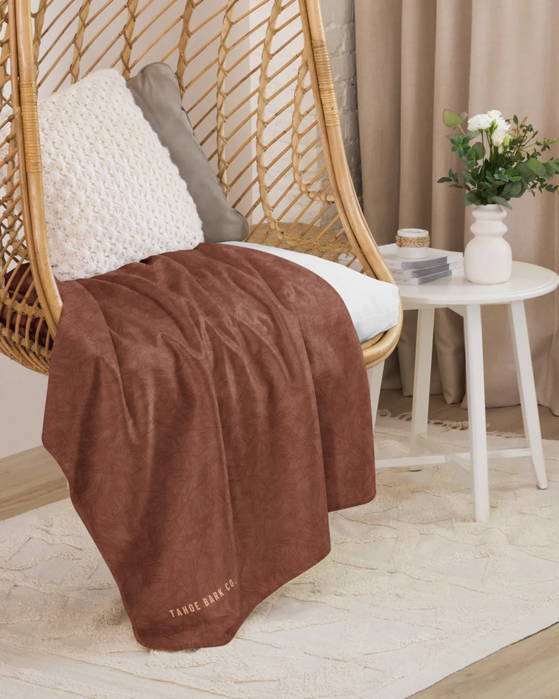 The Coat Match design in Mahogany on a blanket, draped over a hanging chair.