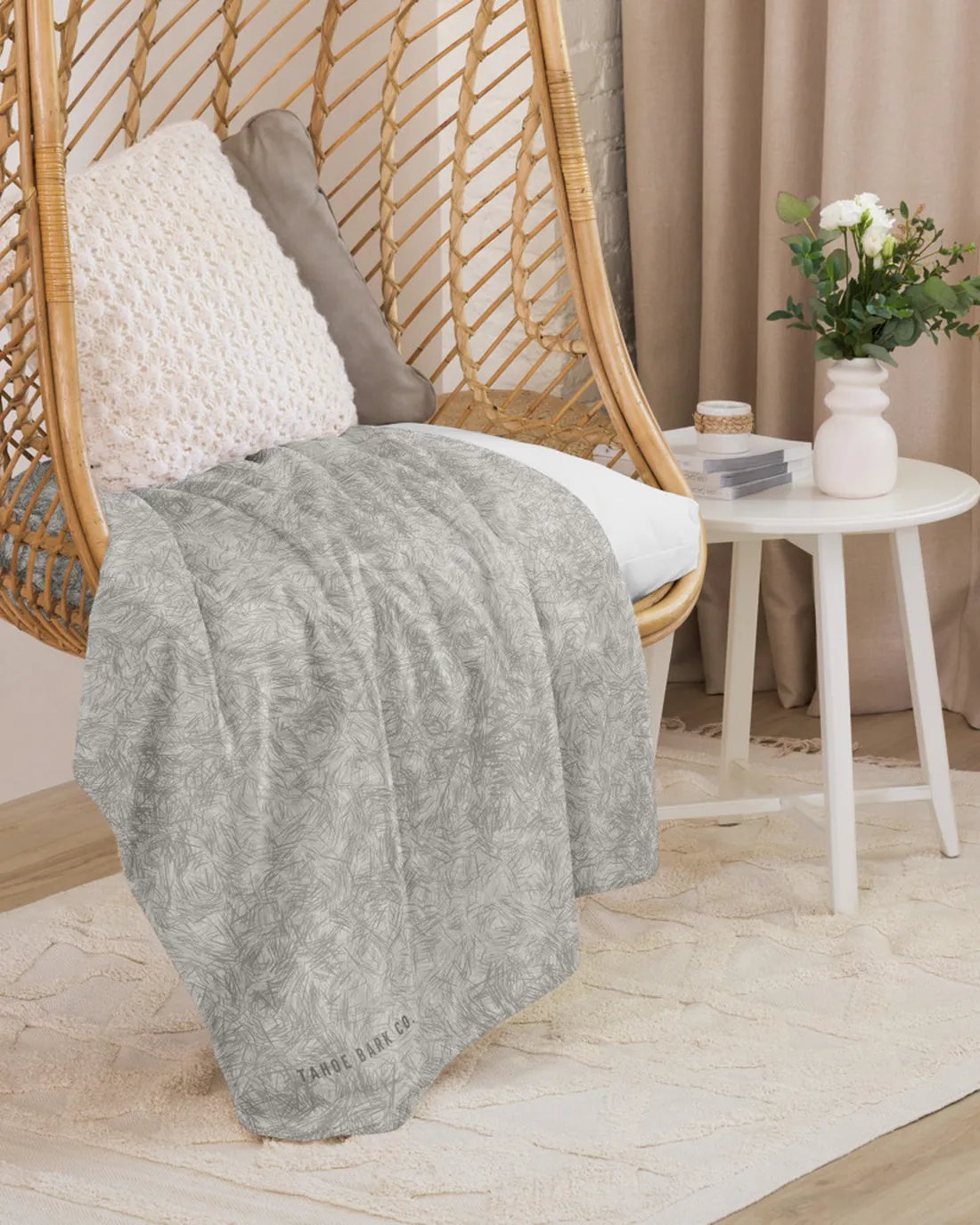 The Coat Match design in Grey and White on a blanket, draped over a hanging chair.