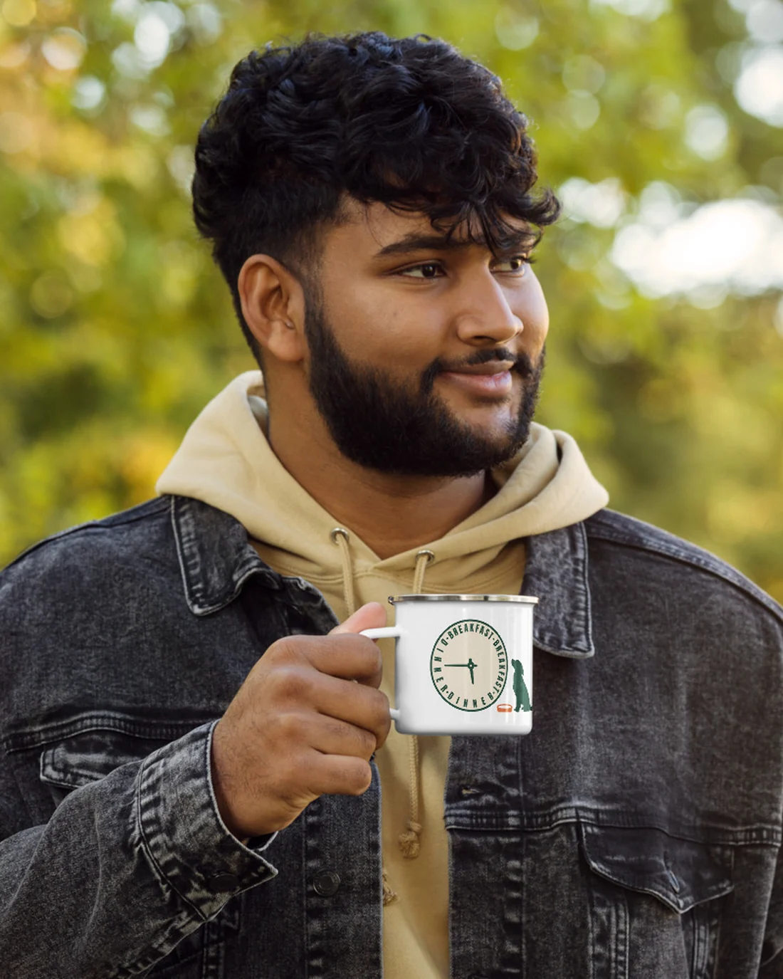 The 5:45 design on an enamel camp mug, held by a model outdoors.