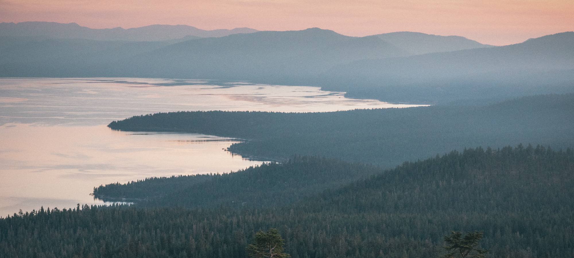 Forested points reaching into Lake Tahoe at sunset, seen from Martis Peak.